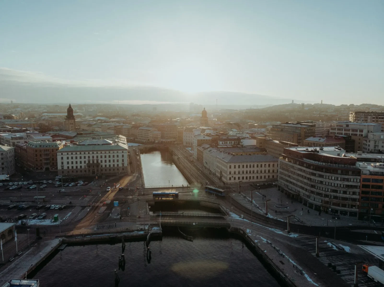 Flygfoto över Göteborg stad med kanal, broar och omgivande byggnader i dimma och motljus vid soluppgång